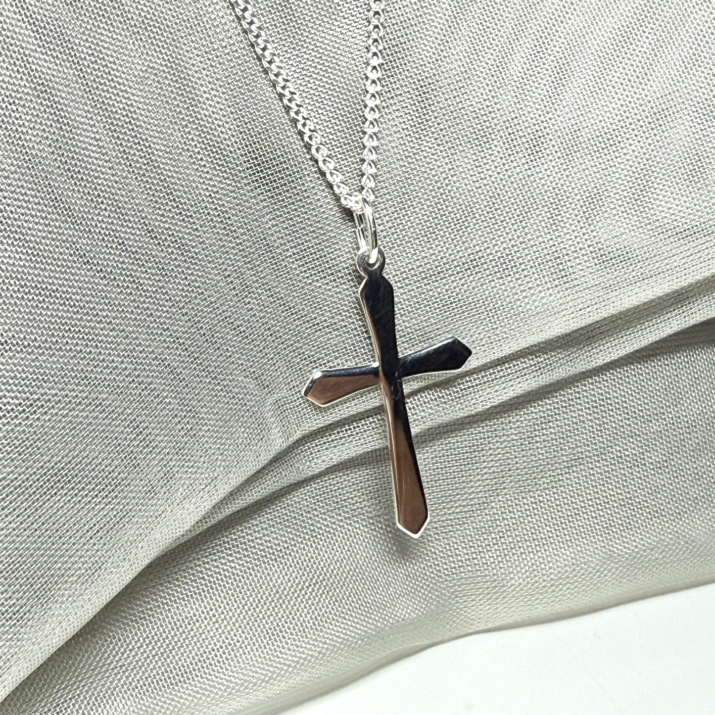 A solid sterling silver cross necklace fancy shaped pendant with a chain