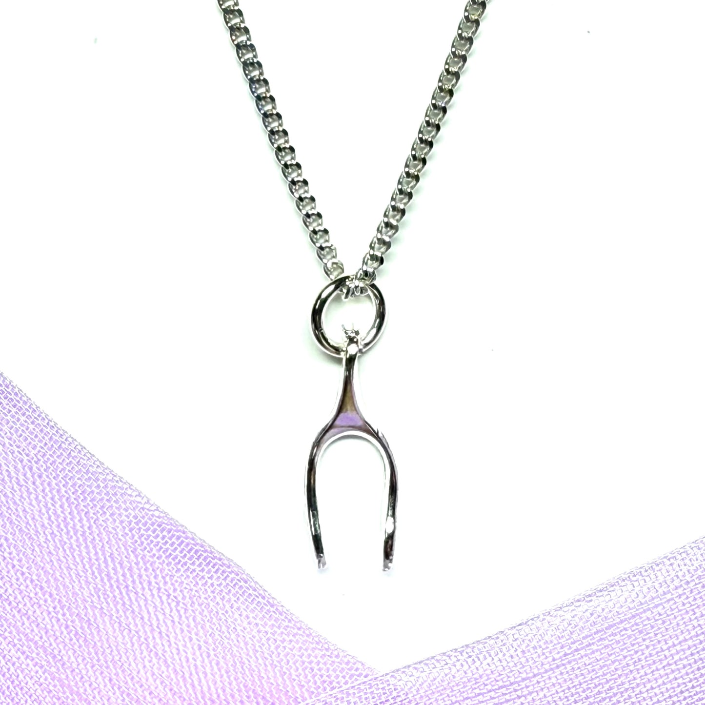 Silver necklace with a wishbone shaped pendant on a white background