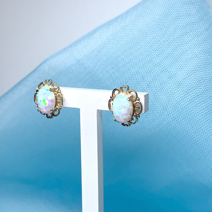 Yellow gold oval opal stud earrings with a pierced setting