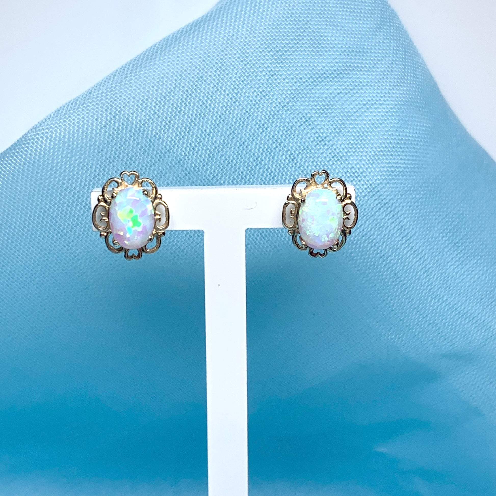 Yellow gold oval opal stud earrings with a pierced setting