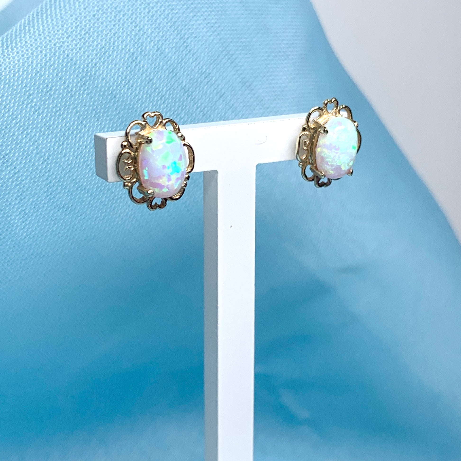 Yellow gold oval opal stud earrings with a pierced setting