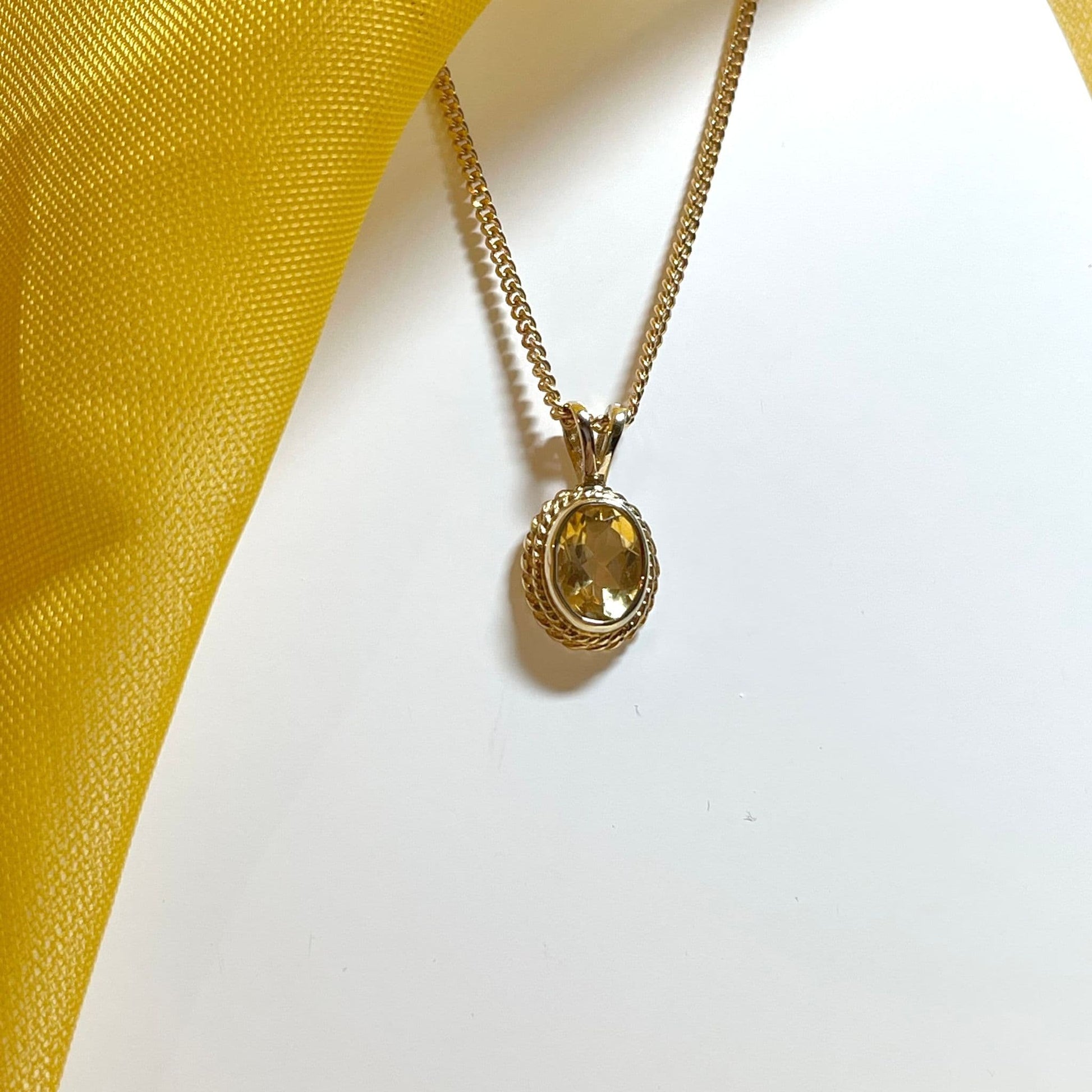 An oval yellow gold citrine necklace