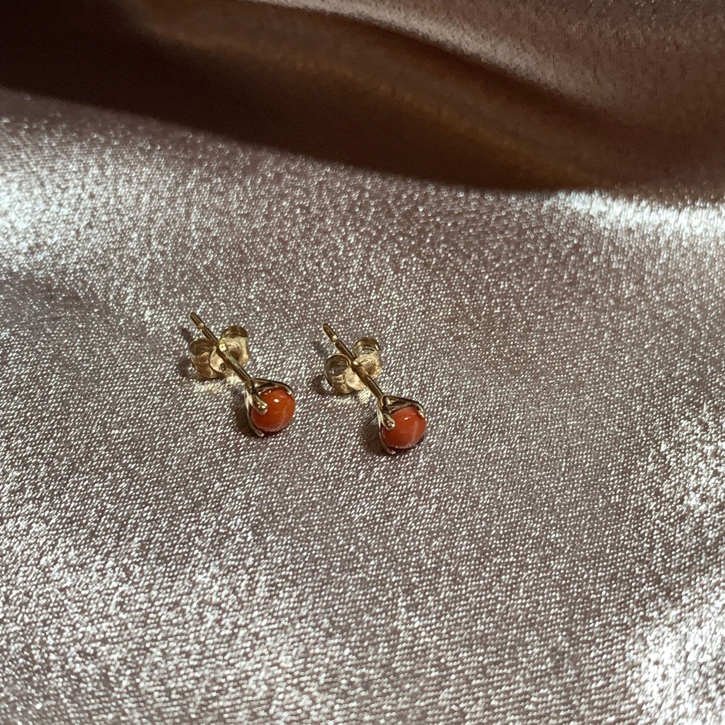 Dark round coral yellow gold claw set stud earrings