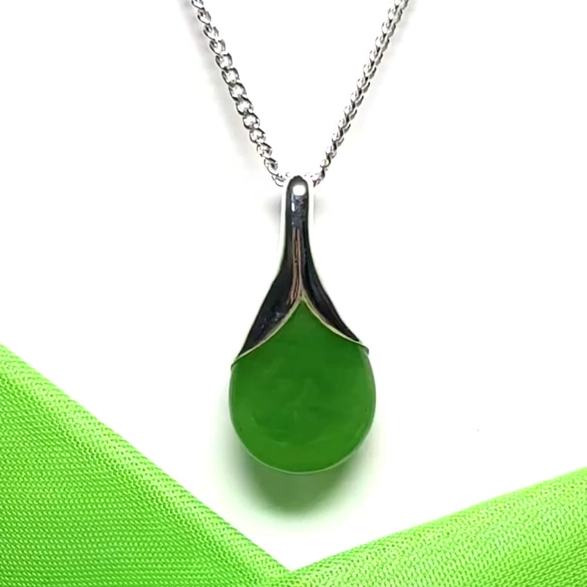 A real green jade pendant necklace in a teardrop shaped or pear shaped including a chain