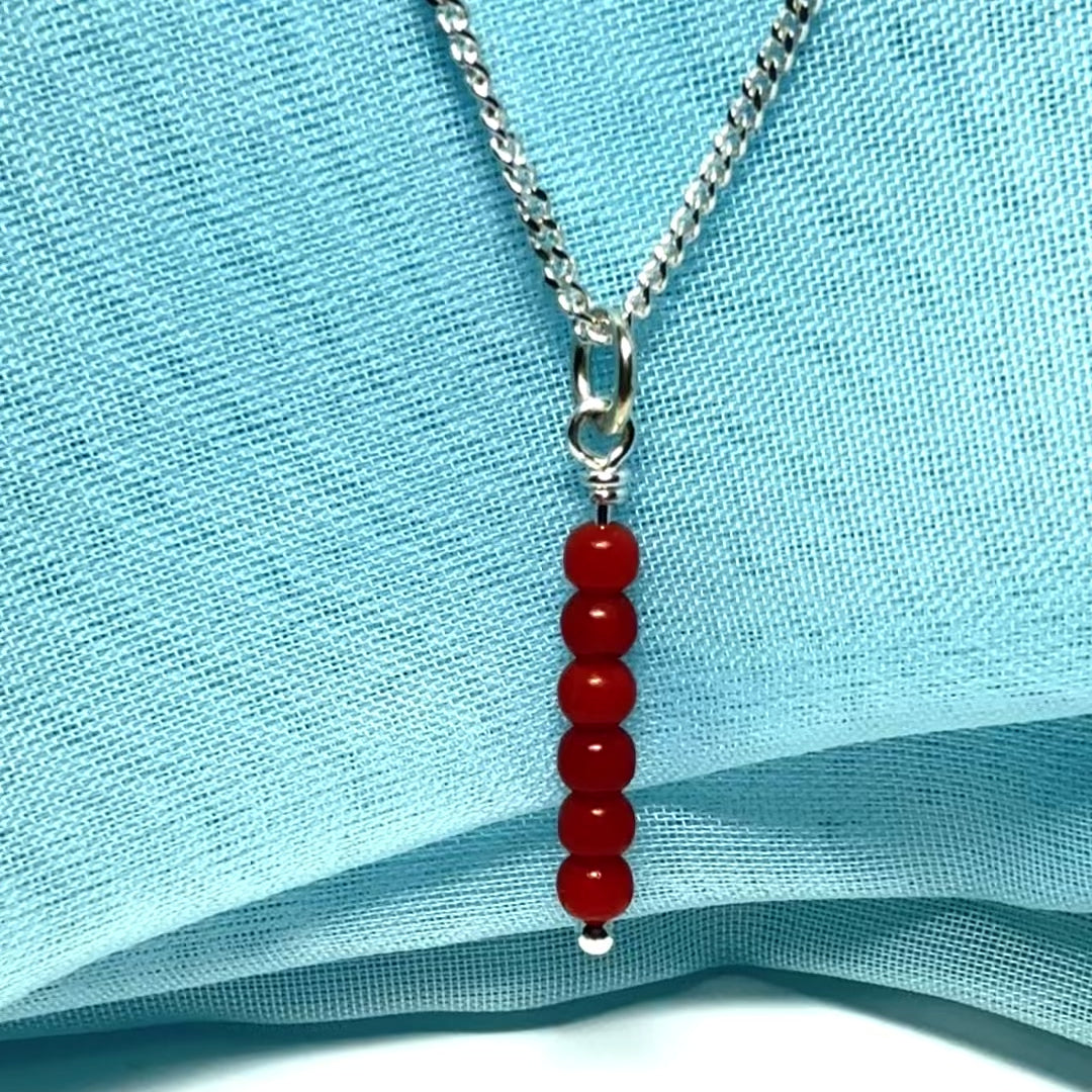 A small real coral necklace round long designed pendant with a chain included as well