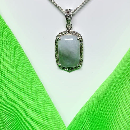 A video of a long cushion shaped light green jade and marcasite silver necklace pendant