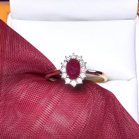 An oval red real ruby and diamond yellow gold cluster ring