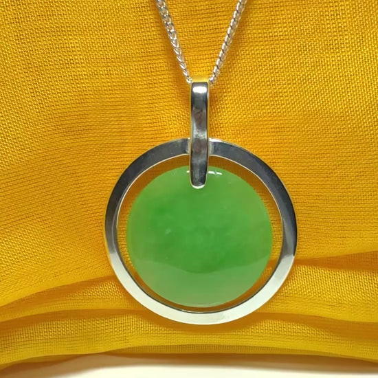 A stunning, shimmering large round halo necklace sterling silver circle shaped green real jade