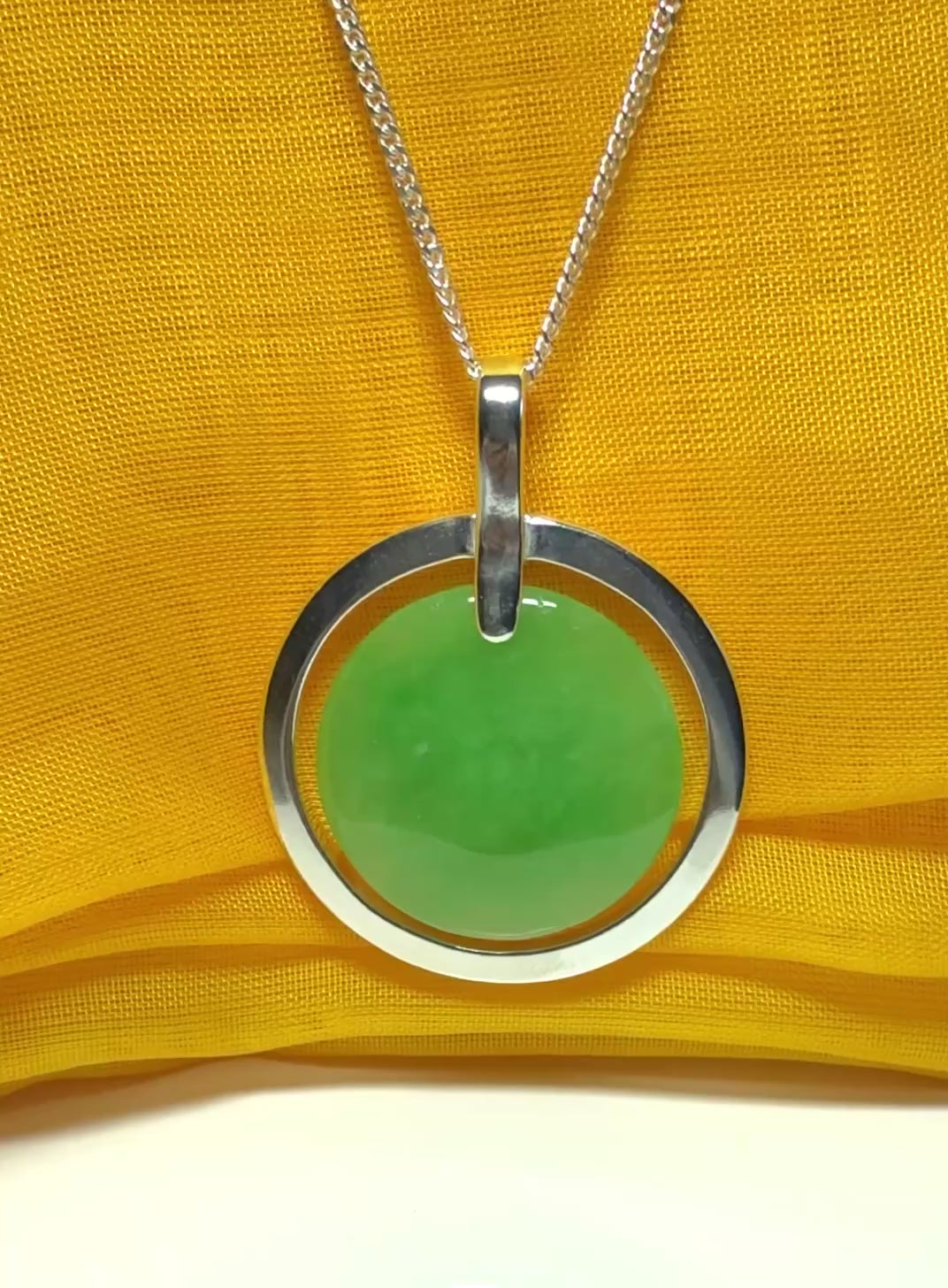 A stunning, shimmering large round halo necklace sterling silver circle shaped green real jade