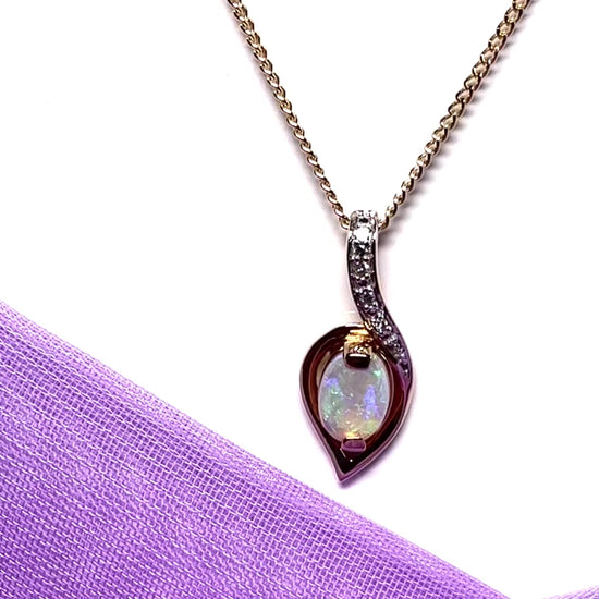 Gold real opal and real diamond necklace pendant oval shaped in a swirl design