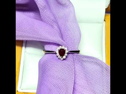 Video of a white gold real ruby and real diamond pear teardrop shaped small cluster ring