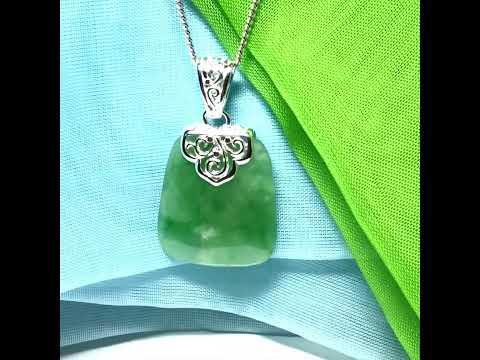 A green real jade necklace with a large shaped and patterned pendant with chain