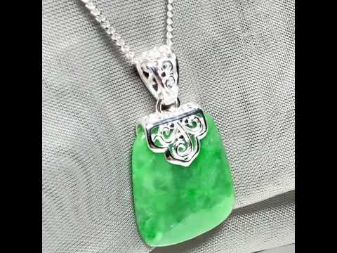 A real green jade necklace large shaped with a patterned top pendant to it with chain