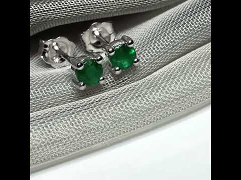 A pair of real green emerald earrings round white gold claw set studs