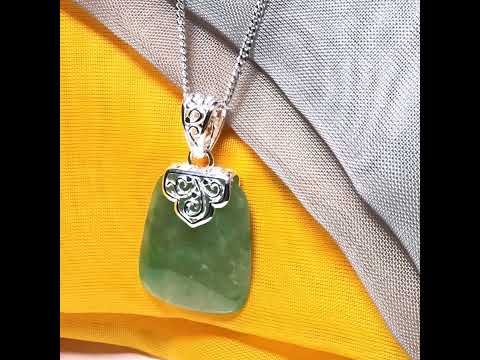 A green real jade necklace with a large shaped and patterned pendant with a chain