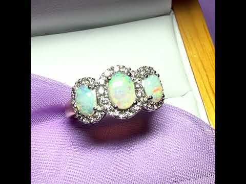 A video of a Gold oval cut three real opal and diamond trilogy cluster ring