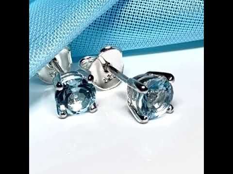Video of a pair of real blue topaz round stud earrings sterling silver claw setting