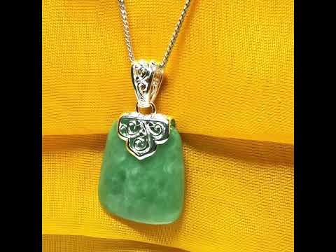 A real green jade necklace with a large shaped and patterned top pendant