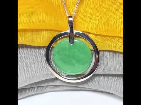 A large sterling silver green real jade necklace halo style, a traditionally designed round pendant