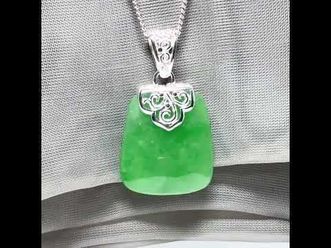 A real green jade necklace with a large shaped and patterned pendant