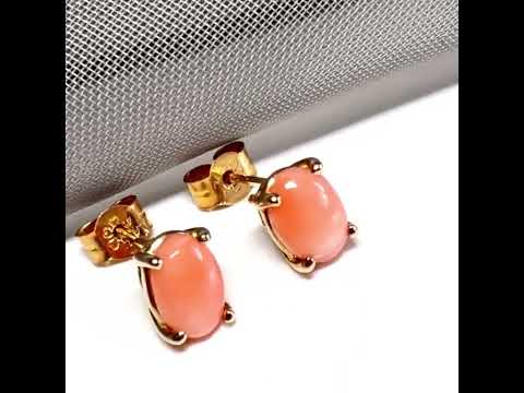 A pair of real coral oval shaped stud earrings yellow gold