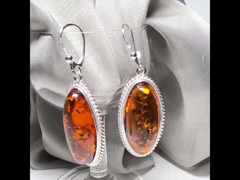 Video of a pair of real amber drop earrings an oval shape rope edged sterling silver continental wired fittings