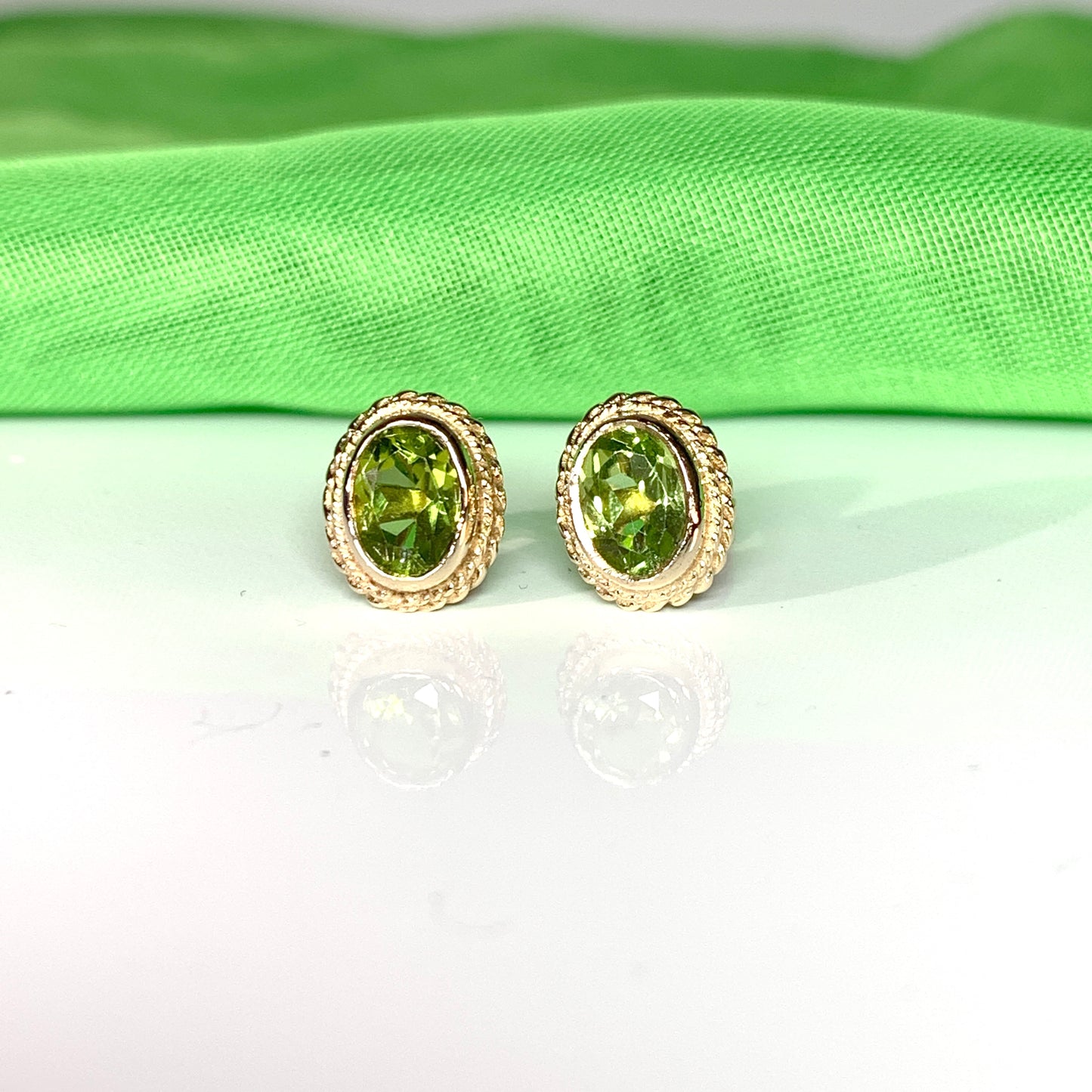 Oval shaped peridot yellow gold rope edged stud earrings