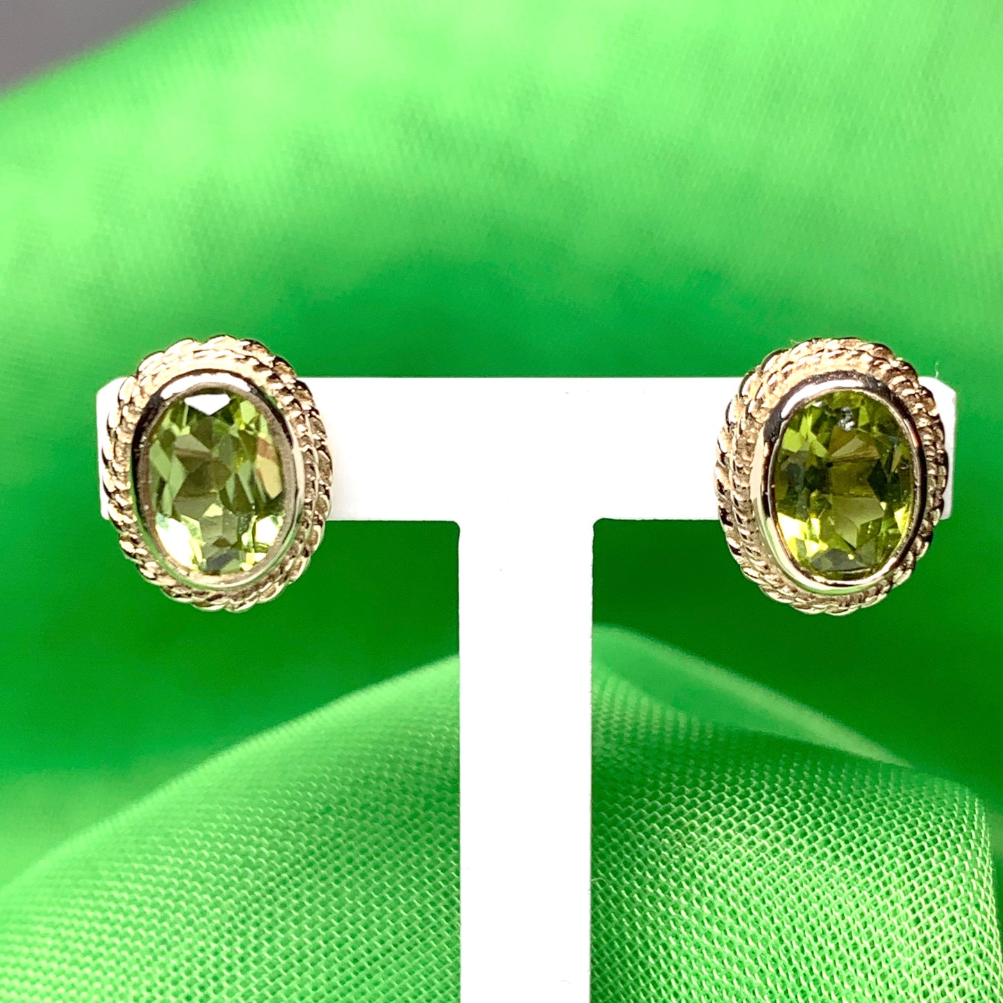 Oval shaped peridot yellow gold rope edged stud earrings